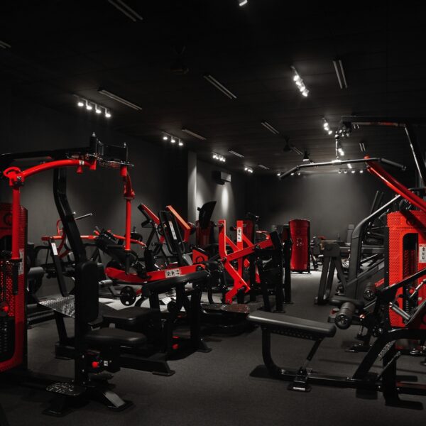 Commercial gym floor fitted out with red and black QLI strength machines