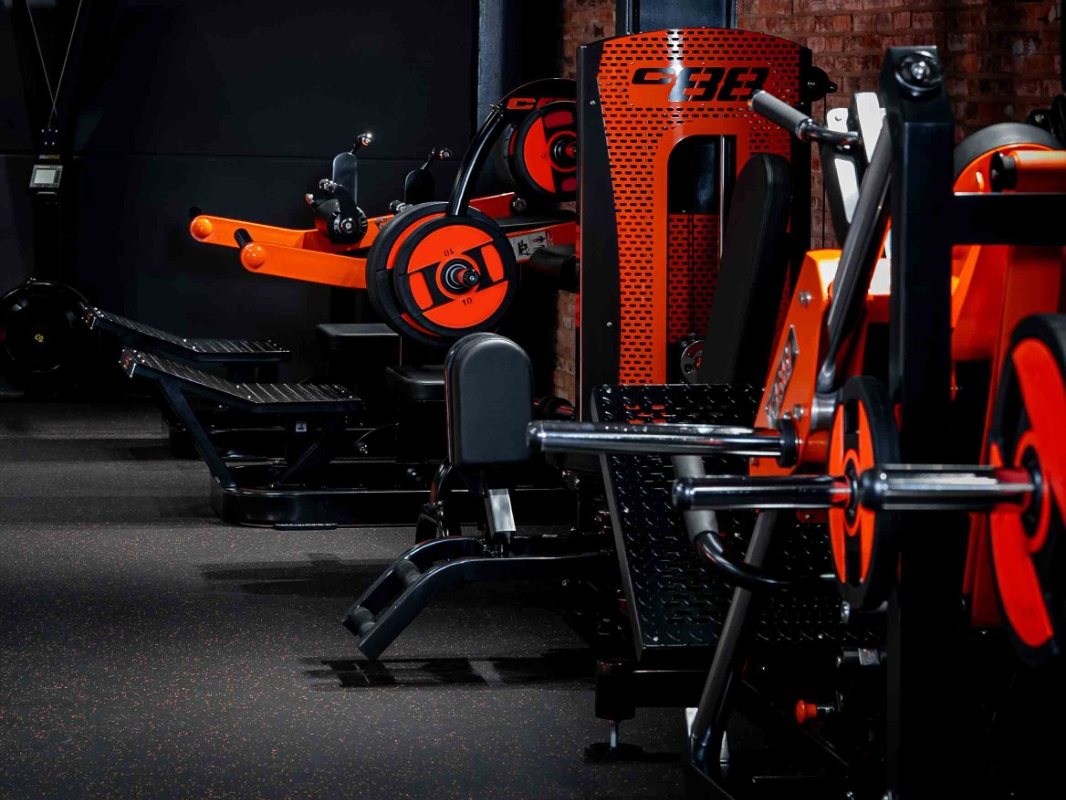 Row of plate-loaded strength machines in a commercial gym
